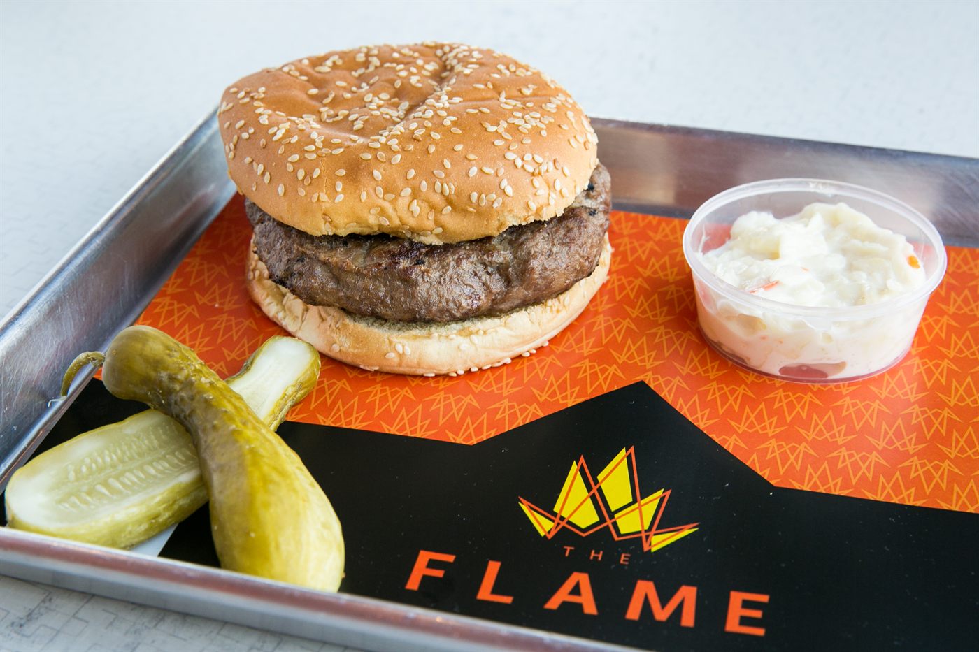 Flame-grilled burger with coleslaw and pickles
